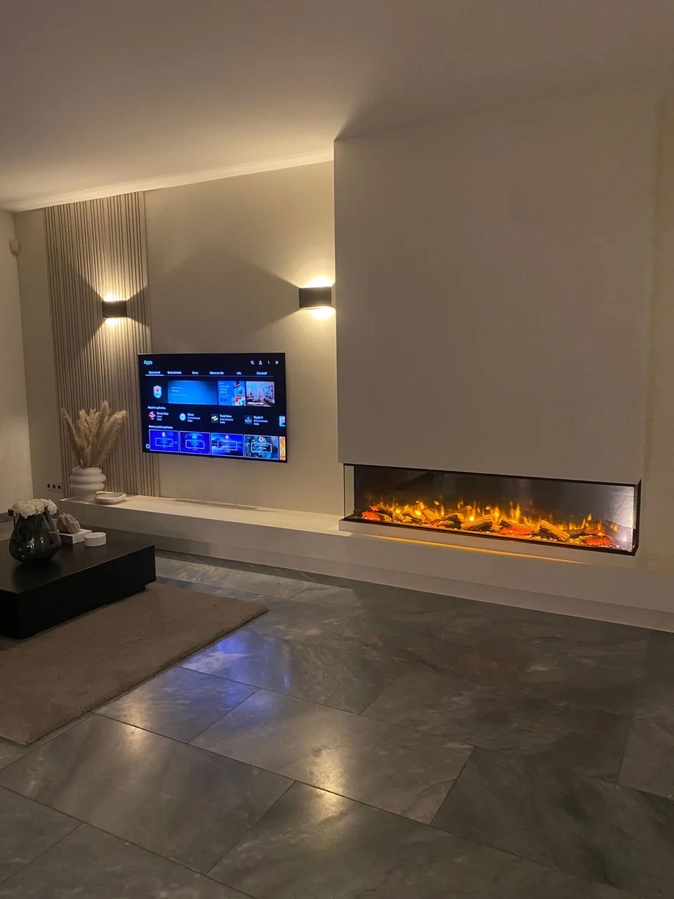 Woonkamer met haardwand en warme wandverlichting